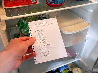 A
              shopping list in front of a refrigerator